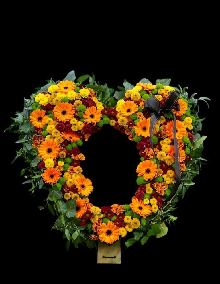 Herzförmiger Blumenkranz aus orangefarbenen und gelben Blumen mit einem schwarzen&nbsp;Hammer.